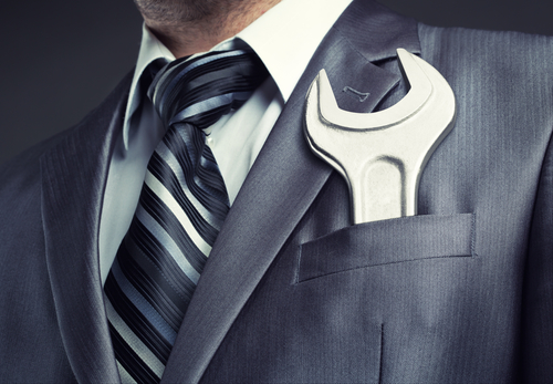 Businessman with spanner in suit pocket